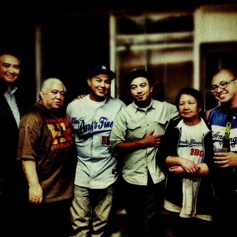 Six smiling people, including three men in "The Park's Finest" shirts, pose together.