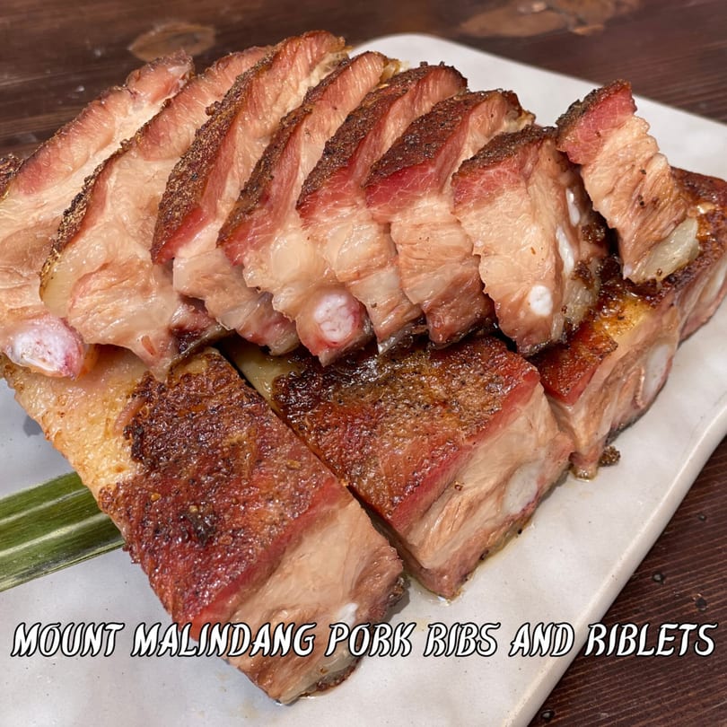 Sliced Mount Malindang Pork Ribs and Riblets, showing tender meat and crispy skin on a white plate.