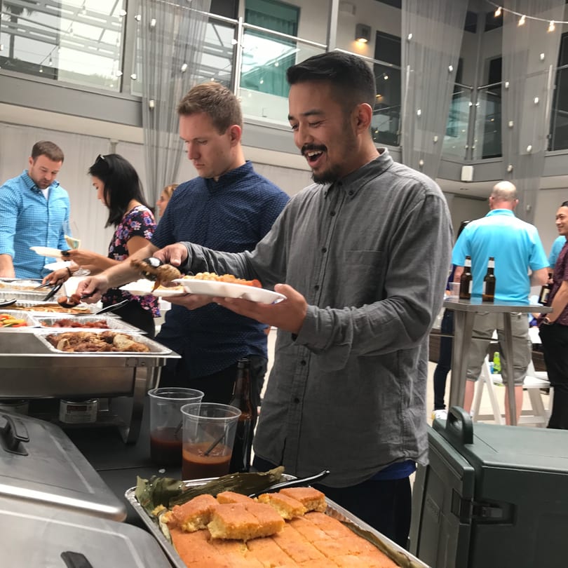 Guests at The Park's Finest buffet line, serving themselves Filipino dishes and desserts.