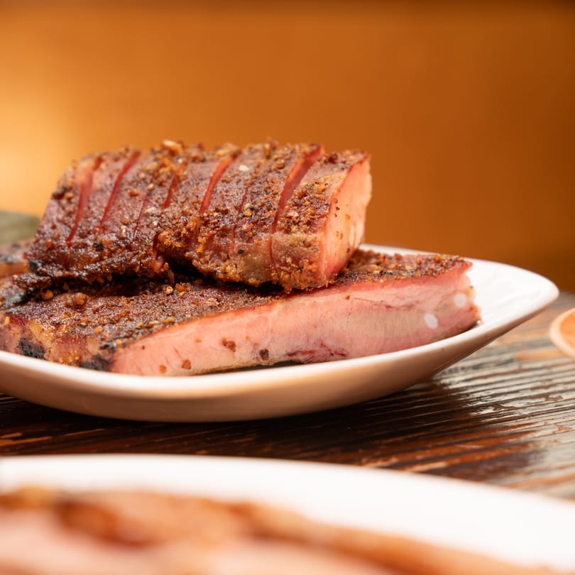 Close-up of The Park's Finest's sliced, seasoned Filipino-style ribs on a white plate.